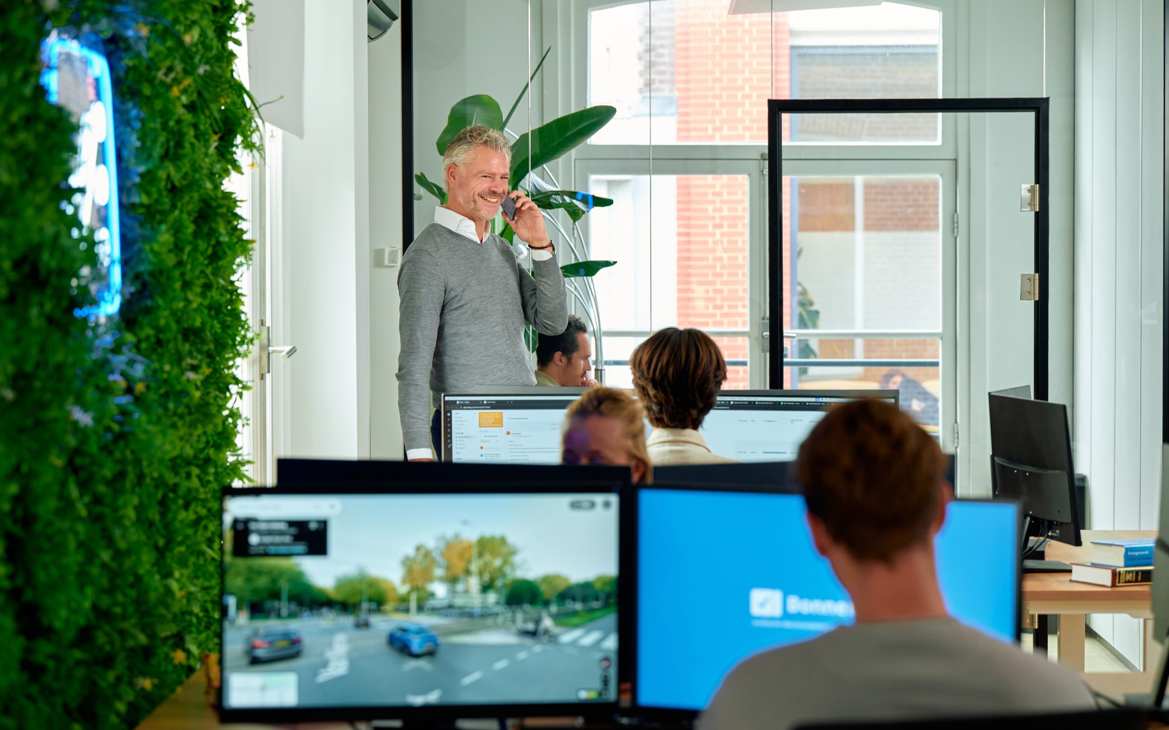 Een Bonnetje-specialist belt met een klant, op de achtergrond het team aan het werk